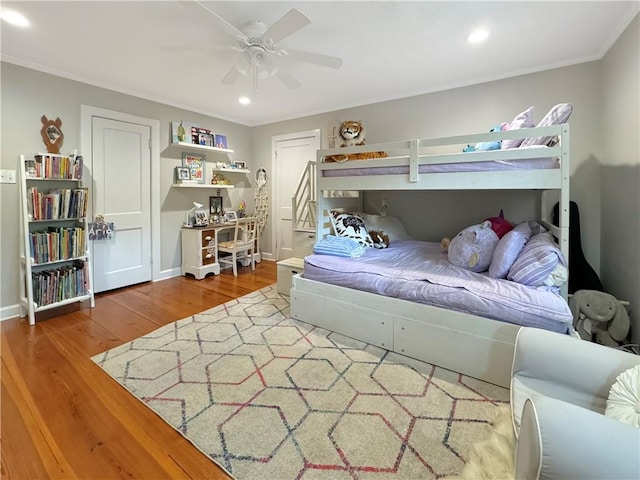 bedroom with hardwood / wood-style floors, ceiling fan, and crown molding