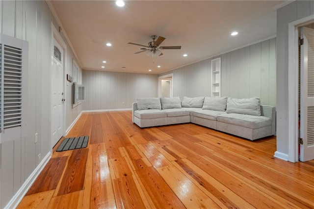 unfurnished living room featuring ceiling fan, light hardwood / wood-style floors, and ornamental molding