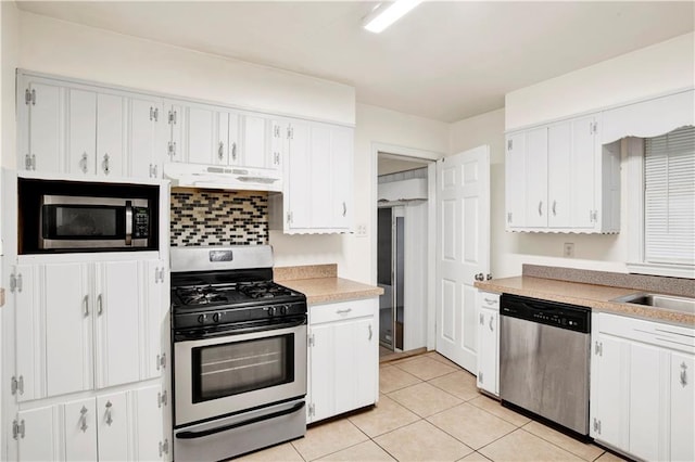 kitchen featuring white cabinetry, backsplash, stainless steel appliances, and light tile patterned flooring