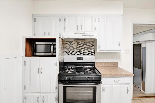 kitchen featuring stainless steel appliances, white cabinetry, tasteful backsplash, and light tile patterned flooring