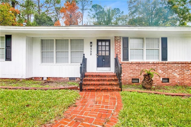 view of exterior entry with a lawn