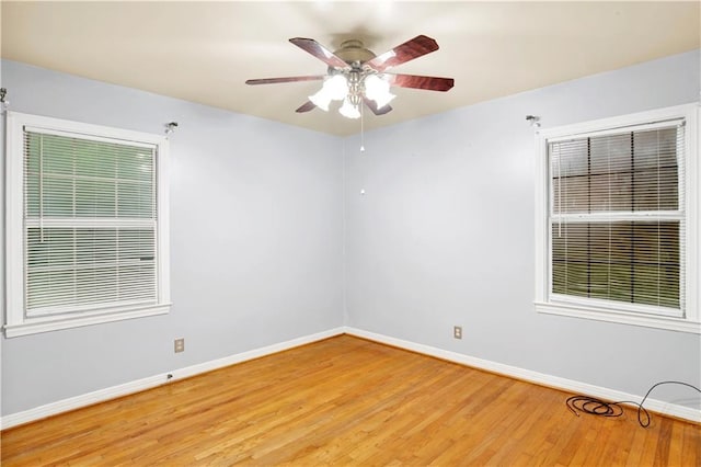 empty room with ceiling fan and light hardwood / wood-style flooring