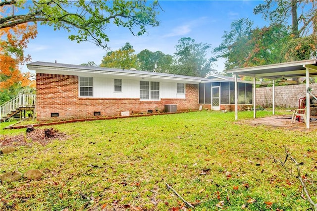 back of house featuring central AC, a sunroom, and a lawn