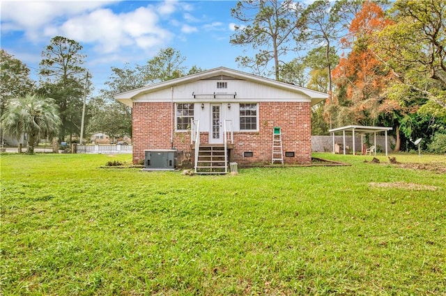 back of property featuring a yard, central AC, and a carport