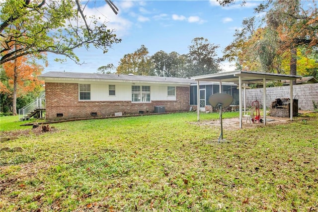 back of property with a yard, central AC unit, and a sunroom