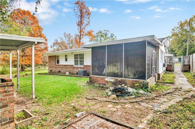 rear view of property with a sunroom, a yard, and cooling unit