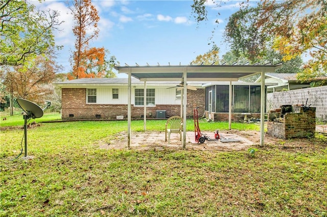 rear view of property featuring a sunroom, central AC unit, and a lawn