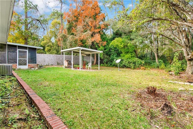 view of yard featuring central AC unit and a sunroom