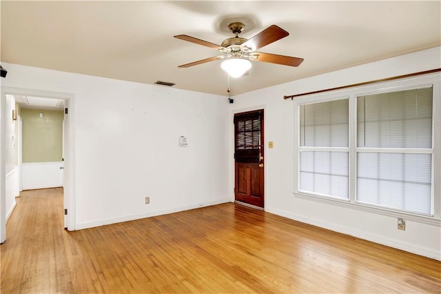 empty room with ceiling fan and light hardwood / wood-style flooring