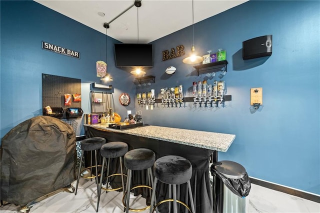 bar with light stone countertops and pendant lighting