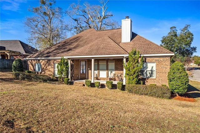 rear view of house featuring a porch and a yard