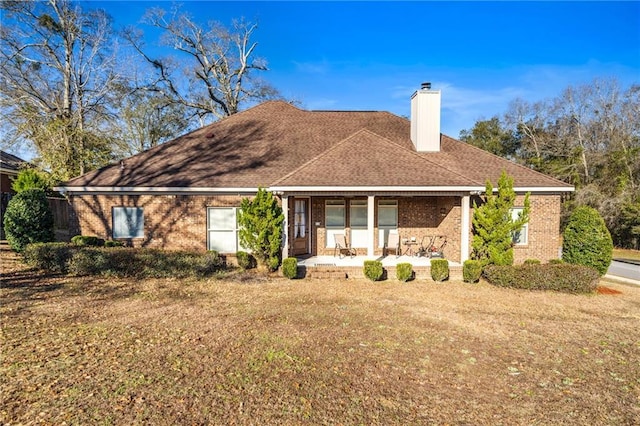 back of house with a lawn and covered porch