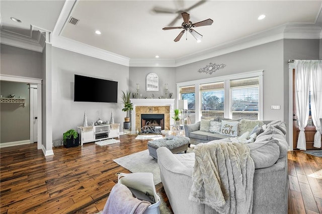 living room featuring crown molding, a fireplace, dark hardwood / wood-style floors, and ceiling fan