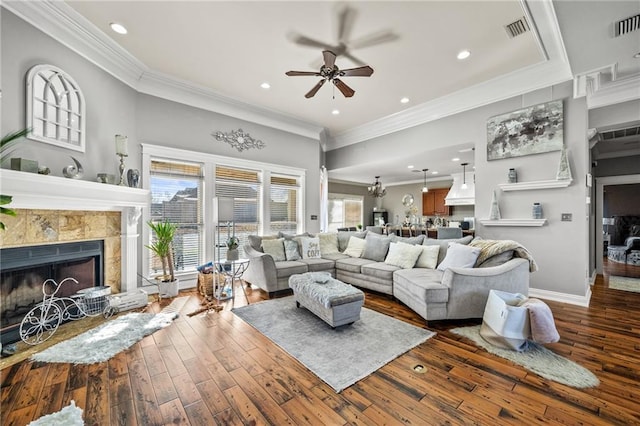 living room featuring crown molding, hardwood / wood-style flooring, a fireplace, and ceiling fan