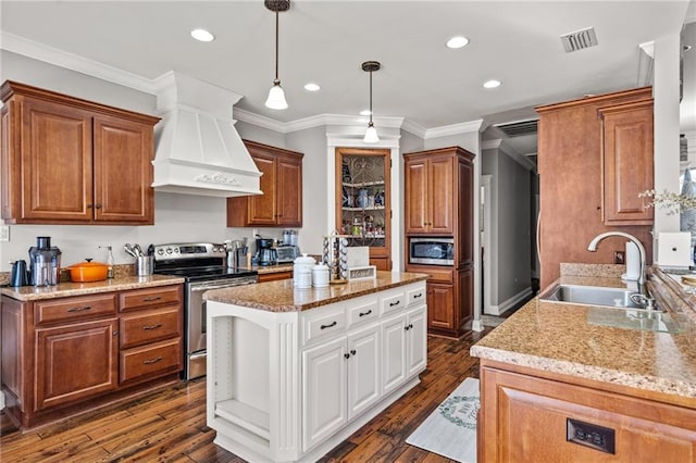 kitchen featuring pendant lighting, sink, premium range hood, appliances with stainless steel finishes, and white cabinets