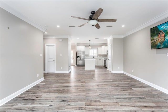 unfurnished living room featuring light wood-type flooring, ceiling fan, and crown molding