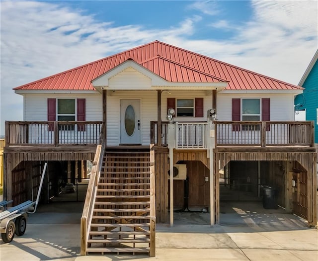 view of front of property with metal roof, stairway, a porch, and concrete driveway