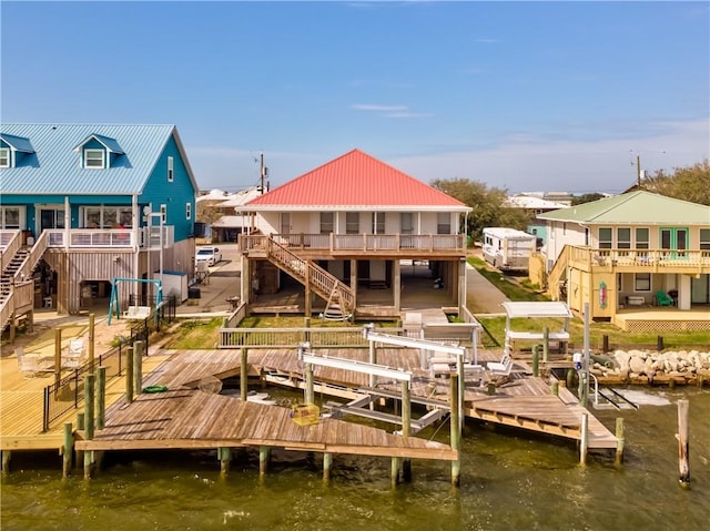 dock area featuring boat lift, stairway, and a deck with water view