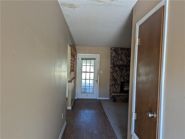 entryway with dark hardwood / wood-style flooring, a fireplace, and a textured ceiling