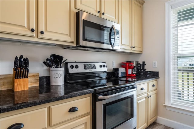 kitchen with stainless steel appliances and dark stone counters