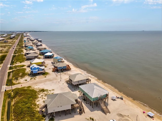 drone / aerial view with a water view and a beach view