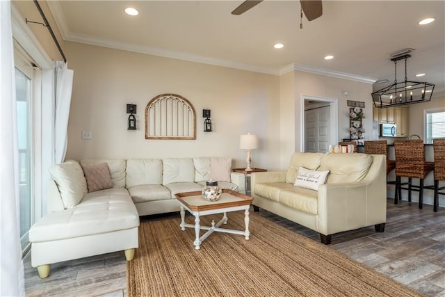 living room featuring crown molding, hardwood / wood-style floors, and ceiling fan