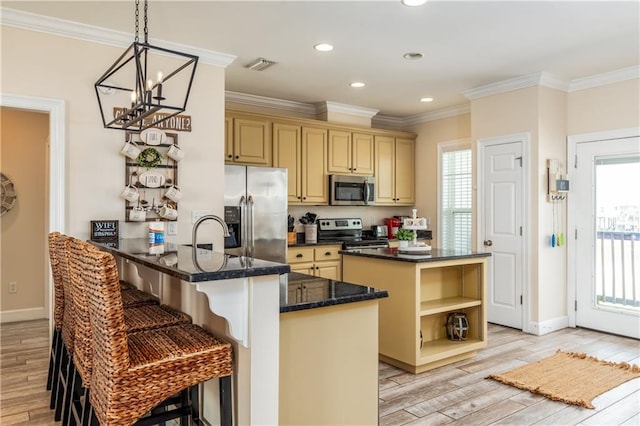 kitchen with appliances with stainless steel finishes, pendant lighting, a kitchen breakfast bar, kitchen peninsula, and crown molding