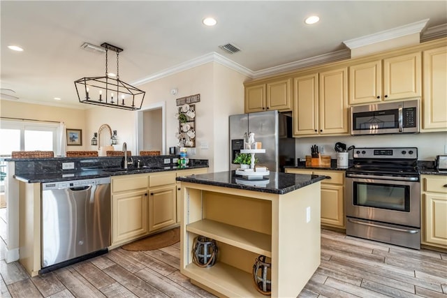 kitchen featuring appliances with stainless steel finishes, hanging light fixtures, a kitchen island, and dark stone countertops