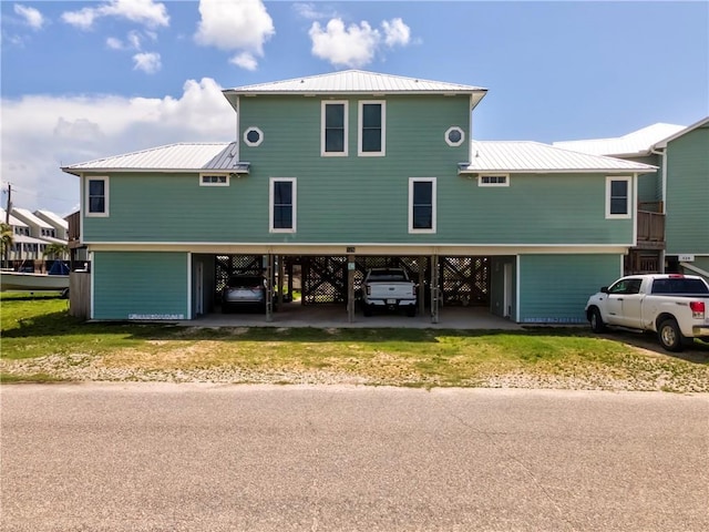 528 Lemoyne Dr Unit 2C, Dauphin Island, AL 36528 - rear view of house featuring a carport, a metal roof, and driveway