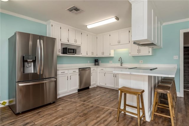 528 Lemoyne Dr Unit 2C, Dauphin Island, AL 36528 - kitchen with stainless steel appliances, ornamental molding, white cabinets, light countertops, and dark wood finished floors