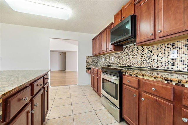 kitchen with decorative backsplash, light tile patterned floors, and appliances with stainless steel finishes