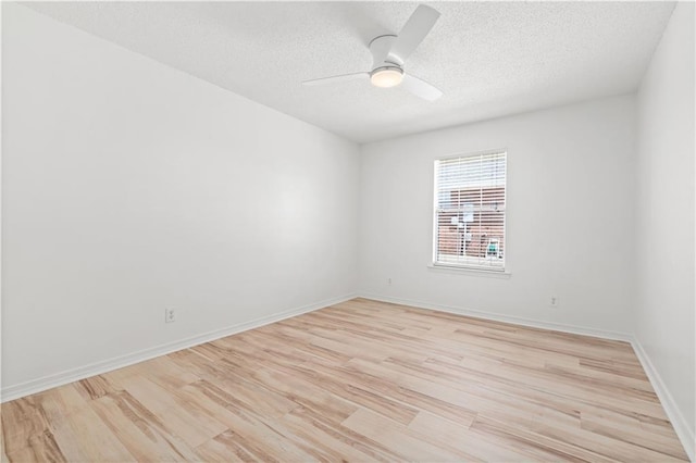 empty room featuring ceiling fan, light wood-type flooring, and a textured ceiling