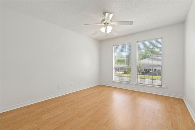 empty room with a textured ceiling, light hardwood / wood-style floors, and ceiling fan