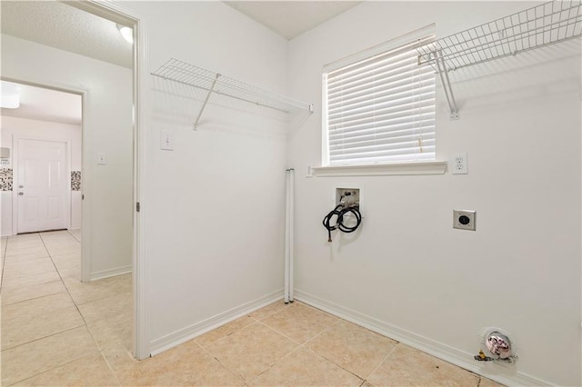 washroom with electric dryer hookup, hookup for a washing machine, and light tile patterned floors