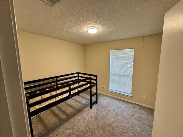 carpeted bedroom featuring a textured ceiling