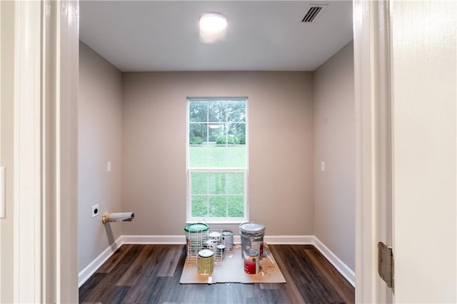 interior space featuring baseboards, a healthy amount of sunlight, and dark wood finished floors