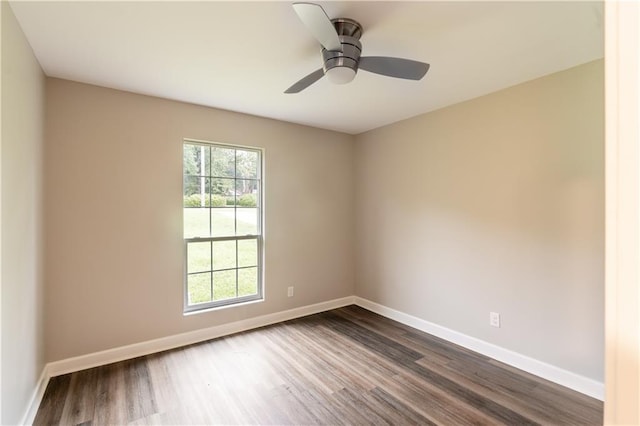 unfurnished room featuring a ceiling fan, dark wood-style floors, and baseboards