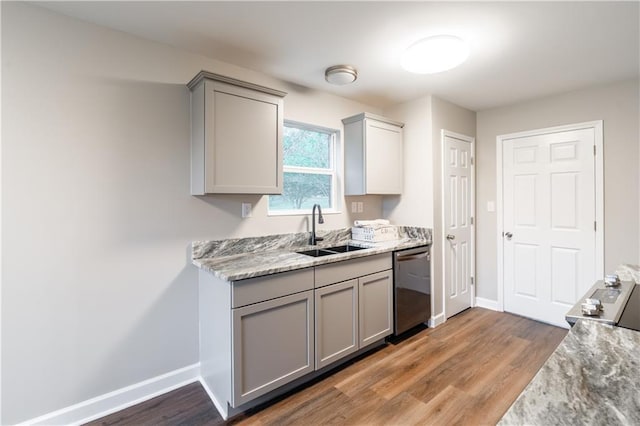 kitchen with baseboards, gray cabinets, a sink, light wood-style floors, and dishwasher