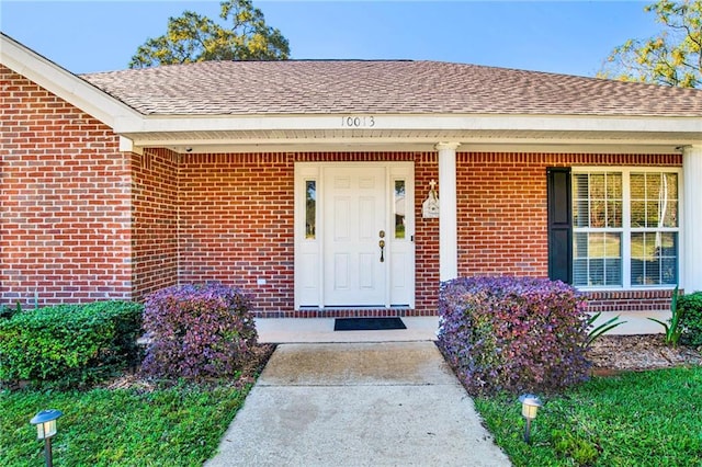 view of exterior entry featuring covered porch