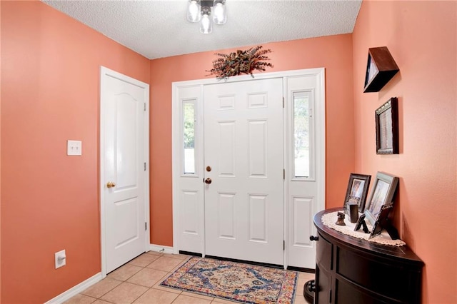 entryway featuring a textured ceiling, light tile patterned floors, and a healthy amount of sunlight