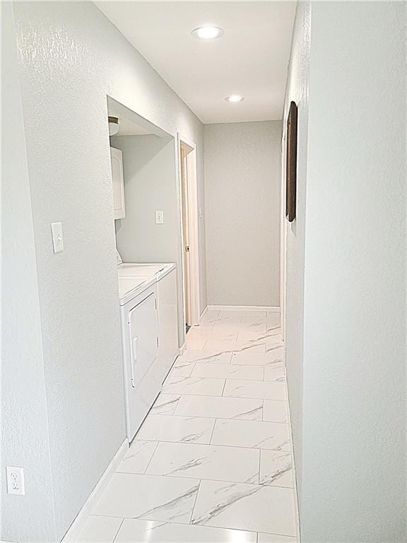 corridor with recessed lighting, marble finish floor, baseboards, and washing machine and clothes dryer