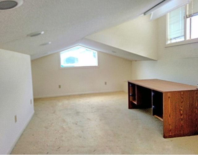 bonus room featuring light carpet and vaulted ceiling