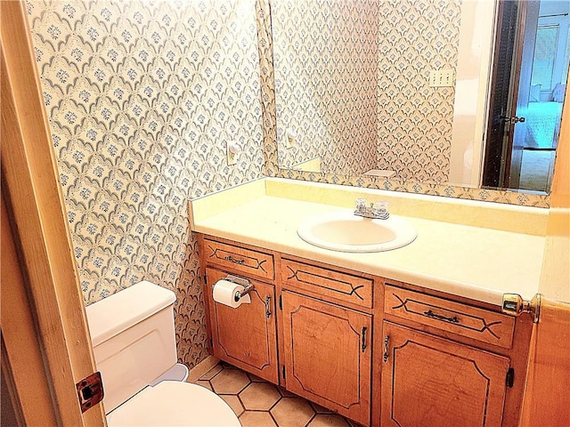 bathroom with tile patterned flooring, vanity, and toilet