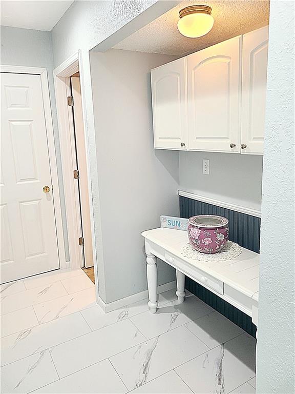 mudroom featuring marble finish floor and baseboards