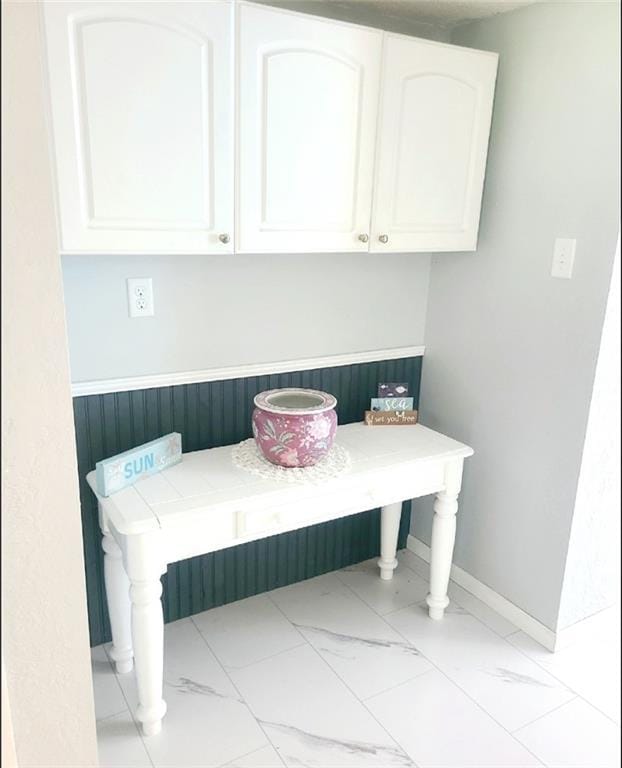 mudroom with marble finish floor and baseboards