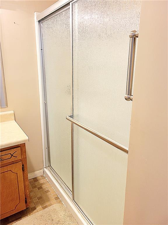 full bath featuring a shower stall and vanity