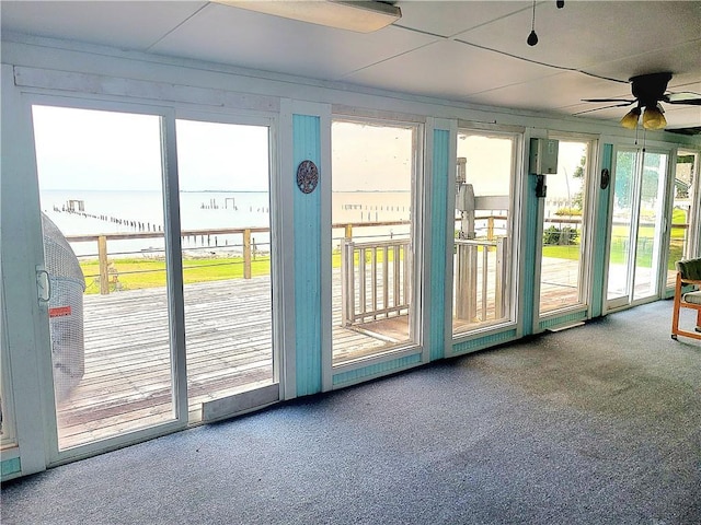 doorway to outside with ceiling fan, carpet floors, and a sunroom