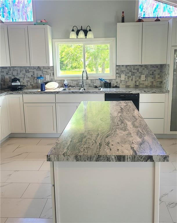 kitchen featuring marble finish floor and white cabinets