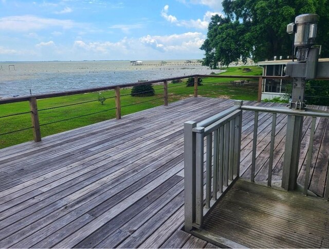 wooden terrace with a lawn and a water view