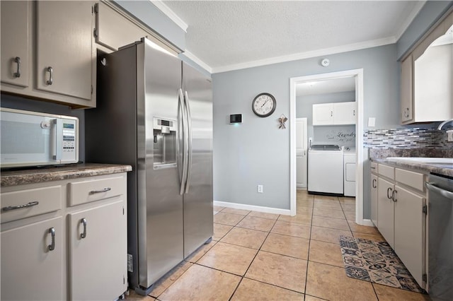 1120 Abilene Dr W, Mobile, AL 36695 - kitchen featuring stainless steel appliances, independent washer and dryer, crown molding, light tile patterned flooring, and backsplash
